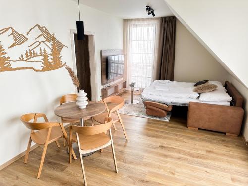 1 dormitorio con 1 cama, mesa y sillas en Apartmány nad Anenským potokem - Říčky en Říčky