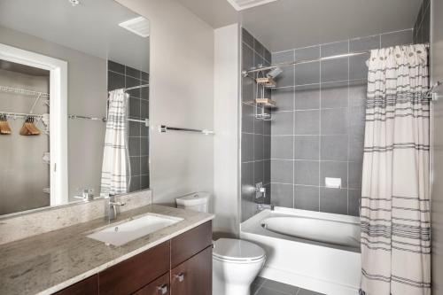 a bathroom with a sink and a toilet and a tub at Bethesda 2br w wd gym pool nr dining WDC-660 in Bethesda