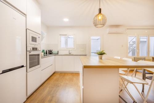 a kitchen with white cabinets and a wooden table at Casa Olegari in Almacellas
