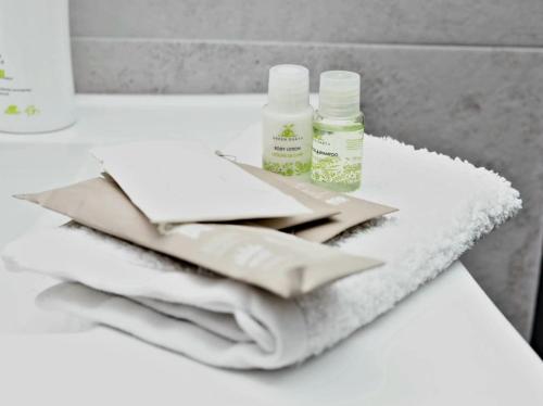 a white counter with two bottles of soap and towels at Yvett Studio-Fortuna Park in Sfântu-Gheorghe