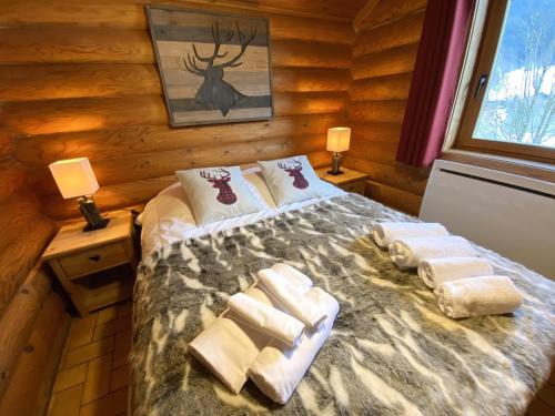 ein Schlafzimmer mit einem Bett in einem Blockhaus in der Unterkunft LE GRAND CERF Chalet en rondins avec SPA Jacuzzi in La Bresse
