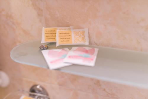 two cards sitting on a glass shelf in a bathroom at Casa San Giuseppe in Rome