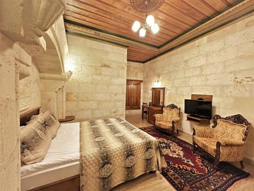 a bedroom with a bed and a tv in a room at Stone House Cave Hotel in Goreme