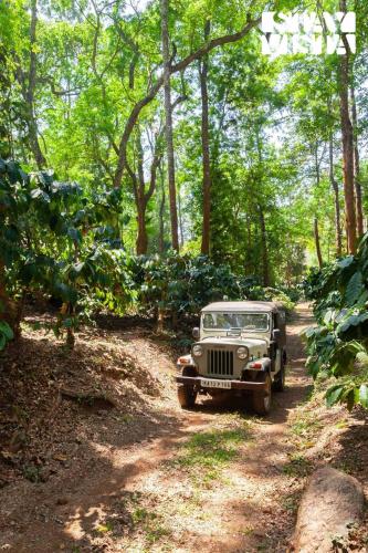 an old car is parked on a dirt road at 3BR Mercara Hill Villa with Outdoor Jacuzzi and Complimentary breakfast - Coorg in Madikeri