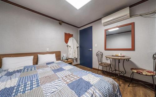 a bedroom with a bed and a table and a mirror at GwiBinJang Motel in Paju