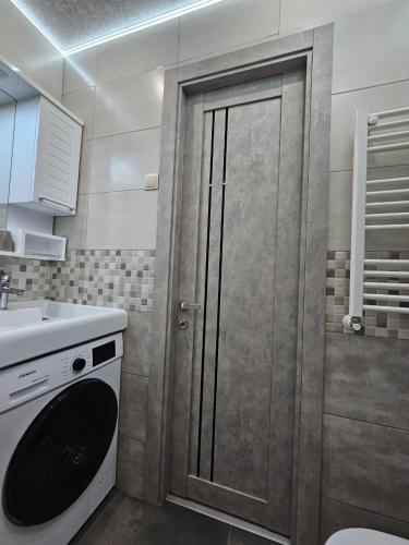a kitchen with a door with a sink and a washing machine at TWO-ROOM APARTMENTS in BAKURIANI in Bakuriani