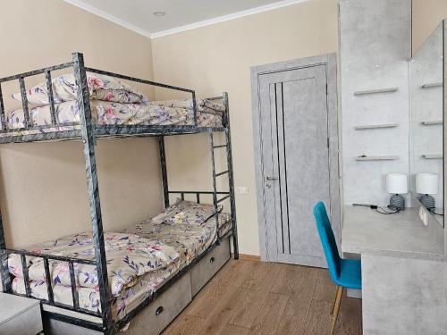a bedroom with two bunk beds and a blue chair at TWO-ROOM APARTMENTS in BAKURIANI in Bakuriani