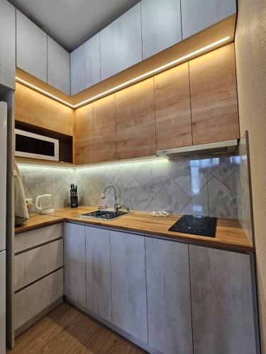 a kitchen with wooden cabinets and a sink at TWO-ROOM APARTMENTS in BAKURIANI in Bakuriani