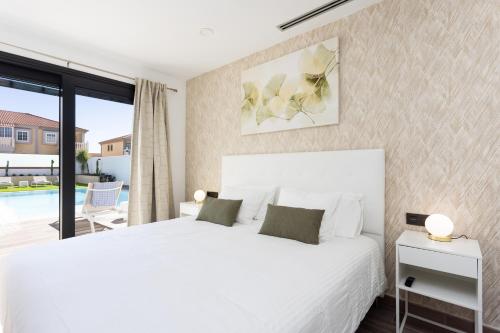 a bedroom with a white bed and a large window at Villa Ikigai By Sunkeyrents in El Médano
