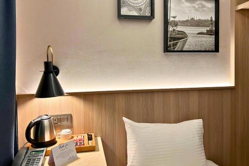 a hotel room with a bed and a phone on a table at Woxx Hotel in Istanbul