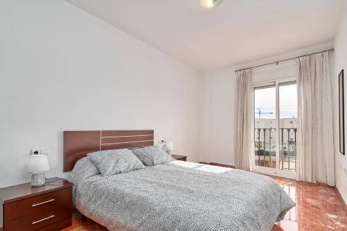 een witte slaapkamer met een bed en een raam bij Casa Axarquia in Vélez-Málaga