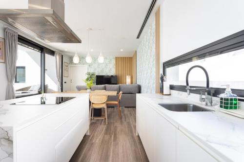 a kitchen with white counters and a dining room at Villa Ikigai By Sunkeyrents in El Médano