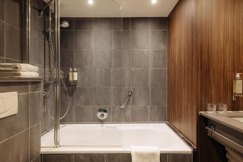 a bathroom with a bath tub and a sink at Eden Hotel Amsterdam in Amsterdam