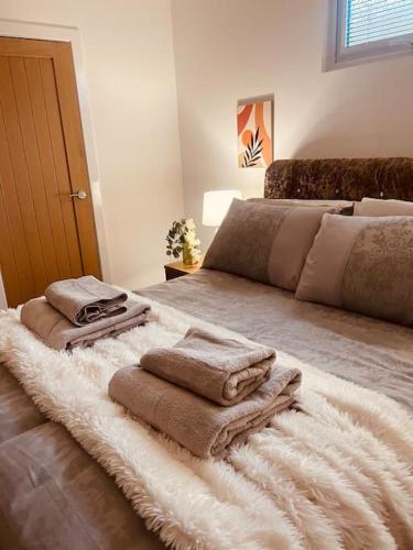 a bedroom with a bed with towels on it at Secret Cabin Getaway in Hartlepool