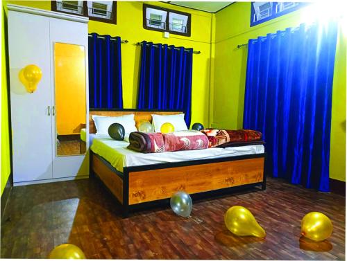 a bedroom with a bed with blue curtains and balloons at Hengdang Resort in Hārmutigāon