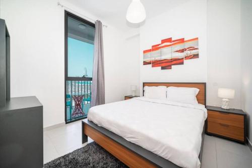 ein Schlafzimmer mit einem Bett und einem großen Fenster in der Unterkunft StoneTree - Cozy Fully-Furnished 1 BR in Dubai