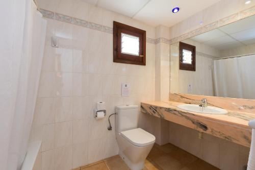 a bathroom with a toilet and a sink at Apartamentos Casa del Sol in Cala Blanca