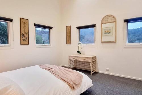 biała sypialnia z łóżkiem i oknami w obiekcie Warburton Valley & Golf Club View w mieście Warburton