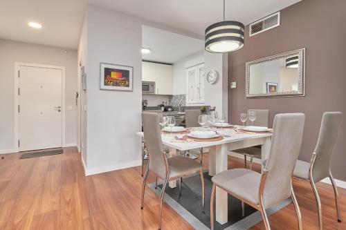 a dining room with a white table and chairs at Apartamento Playa Granada Golf in Motril