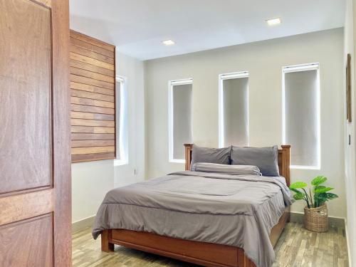 a bedroom with a bed in a room with windows at WH Bassac Residence in Phnom Penh