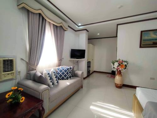 a living room with a couch and a tv at D'Mariners Inn Hotel in Batangas City