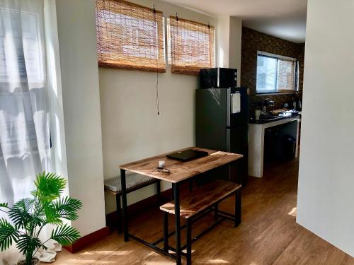 a small kitchen with a table and a refrigerator at The Apartium - Modern Apartment Rentals in Bangkok