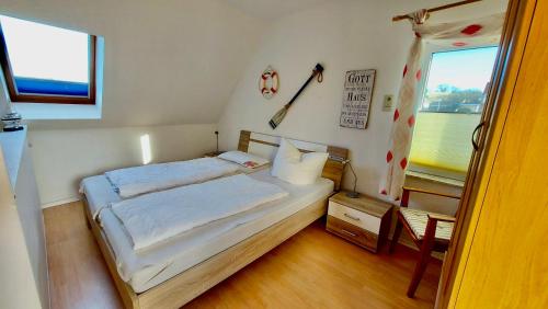a small bedroom with a bed and a window at Ferienwohnung Ankerplatz Thiessow in Thiessow