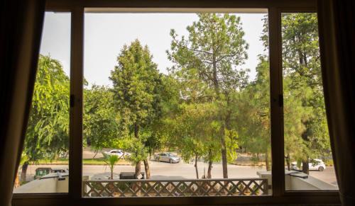 uma janela com vista para um parque de estacionamento em Roomy Signature Hotel, Islamabad em Islamabad