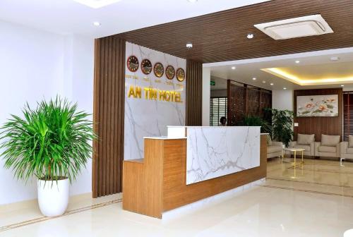 un vestíbulo de oficina con recepción y plantas en An Tín Hotel en Hai Phong