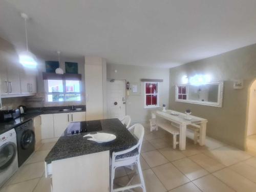 a kitchen with a counter and a table in it at Santorini Beach Views - 23 Perissa in Ballito