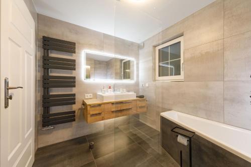 La salle de bains est pourvue d'un lavabo et d'un miroir. dans l'établissement Ferienhaus am Wald, à Wernigerode