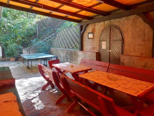 un patio con mesas de madera y sillas en un restaurante en Forrás Vendégház, en Szálka