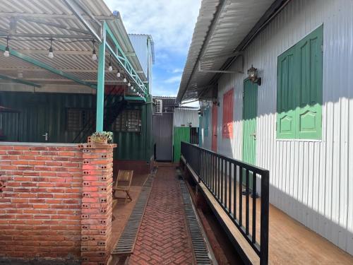 a train station with a brick wall and green doors at Homestay Caskameo Đà Lạt in Tarklette