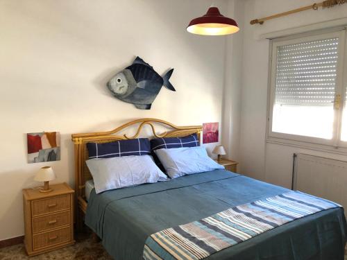 1 dormitorio con 1 cama con un pez en la pared en Be Your Home - Casa Raffaello, en Santa Marinella