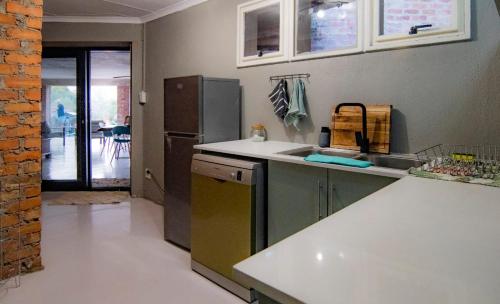 a kitchen with a sink and a refrigerator at The South Post @ Kruger in Marloth Park