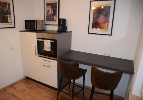 a kitchen with a black counter and two chairs at Ferienwohnung am Rathaus in Landstuhl