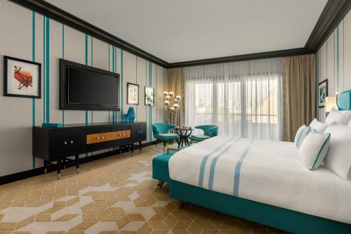 a hotel room with a bed and a flat screen tv at Dinamo Hotel Baku in Baku