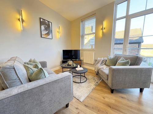a living room with two couches and a tv at Harrogate House Apt 3 - 2 Bed Duplex in Harrogate