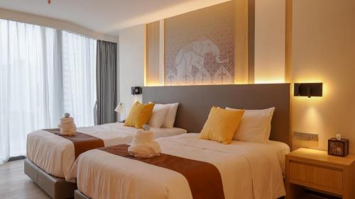 Shenzhen Tower Hotel Thonglor Sukhumvit tesisinde bir odada yatak veya yataklar