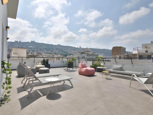 a patio with chairs and tables on a roof at ROOFTOP 42 - Penthouse in Haifa