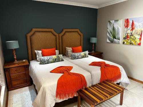 a bedroom with a large bed with orange sheets at Meyers Guesthouse in Jwaneng