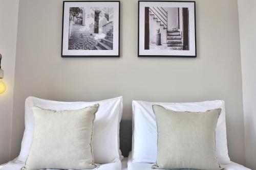 two pillows on a bed with two pictures on the wall at ROOFTOP 42 - Penthouse in Haifa