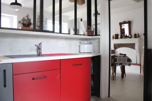 a kitchen with red cabinets and a red sink at 355 - Maison au cœur du Grand site de France du Cap Fréhel in Fréhel