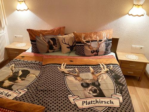 a bed with a picture of a deer and glasses at Alpenfarm Poschhof in Kaunerberg