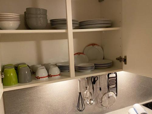 a kitchen cabinet with dishes and plates and utensils at Alpenfarm Poschhof in Kaunerberg