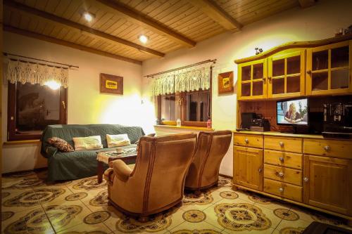 a living room with a couch and a table and chairs at Chatka Pod Trohańcem in Lutowiska