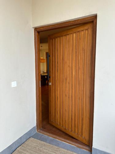 a wooden door in a room with a hallway at The Pent - Richmond in Bangalore