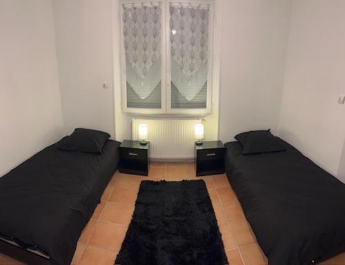 two beds in a room with a window at Gite for you muguet in Neuvy-sur-Loire