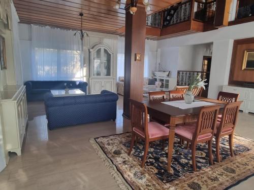 a living room with a table and chairs and a couch at Villa in Trilofos-close to the beach in Thessaloniki
