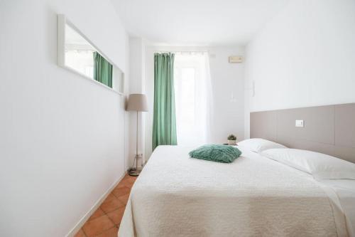 Dormitorio blanco con cama con almohada verde en Appartamento Torrioni - by Casêta en Ancona